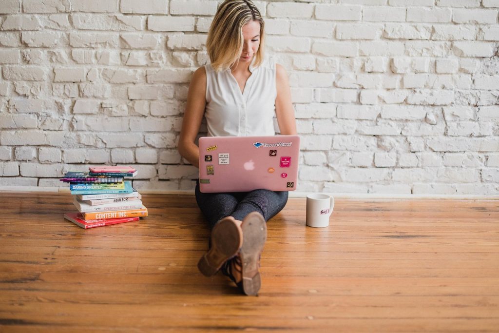 mastering assignment writing Student mastering assignment writing with laptop and academic books