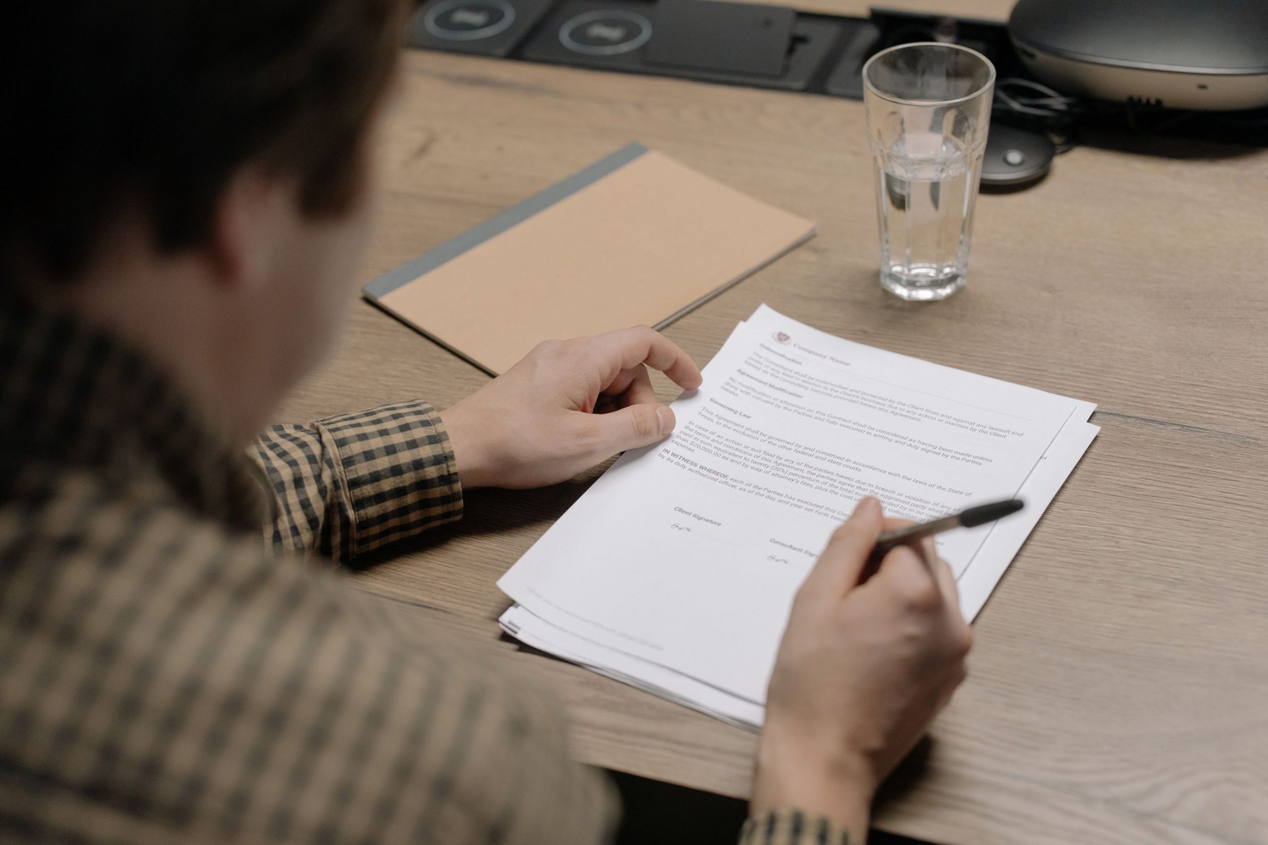A close-up of a person proofreading a document, symbolising the meticulous process of ensuring flawless writing.