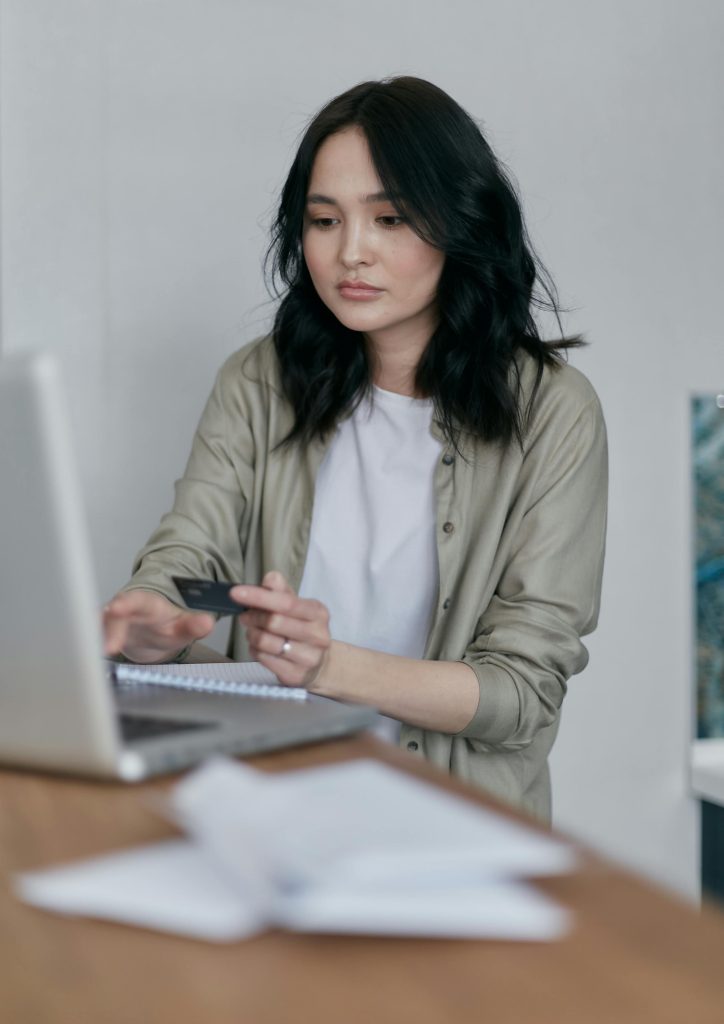 Smiling student with laptop and notebook at desk - Buy Assignment Online UK