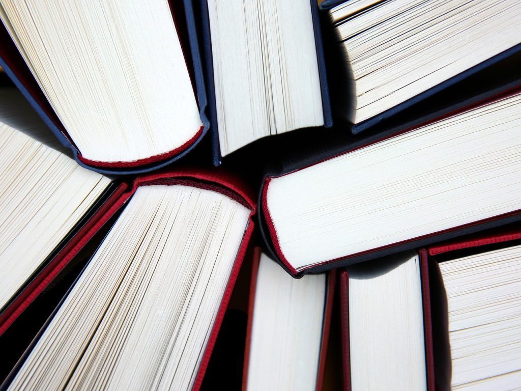 Referencing styles for Mastering Assignment Writing – Harvard and APA overview (stack of books)