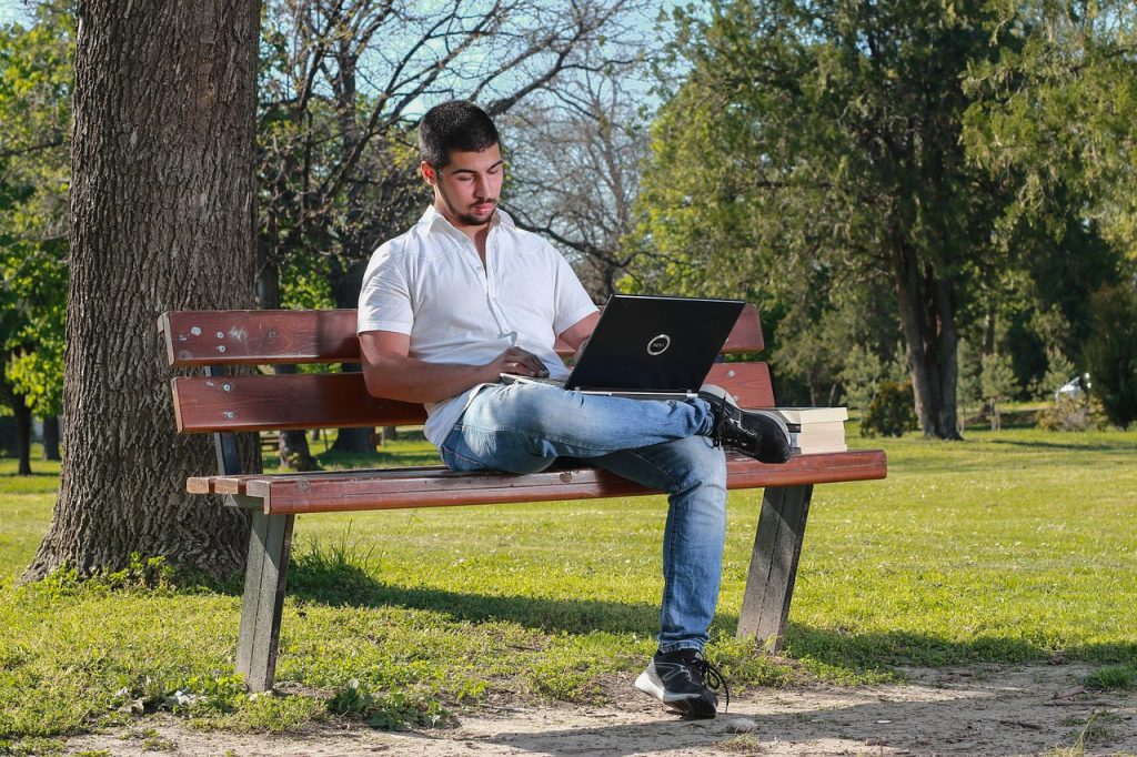 Reflective Essay Topics UK – student writing on a laptop while planning a reflection